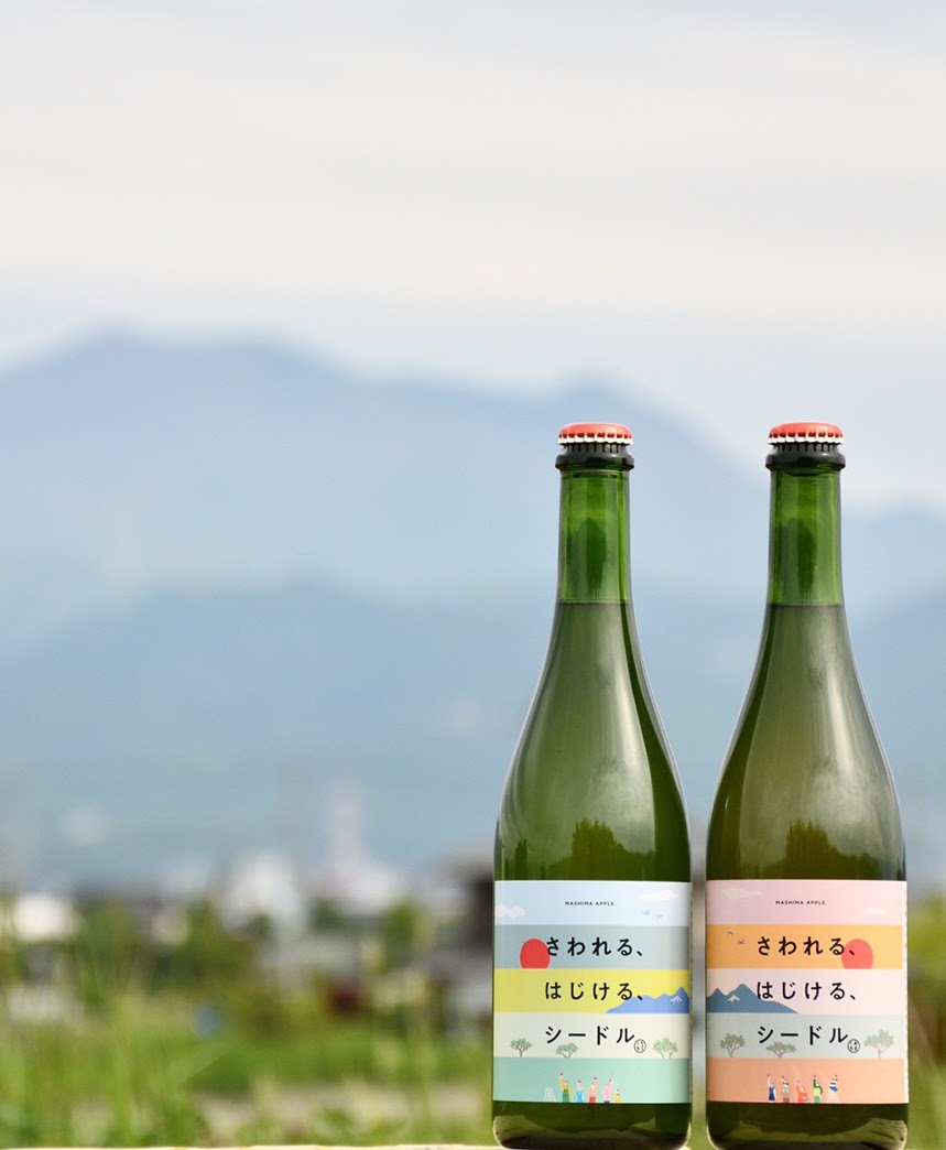 長野の山を背景にしたさわれる、はじける、シードルのボトル